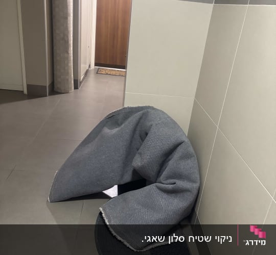 שטיח מגולגל ליד דלת כניסה בבניין